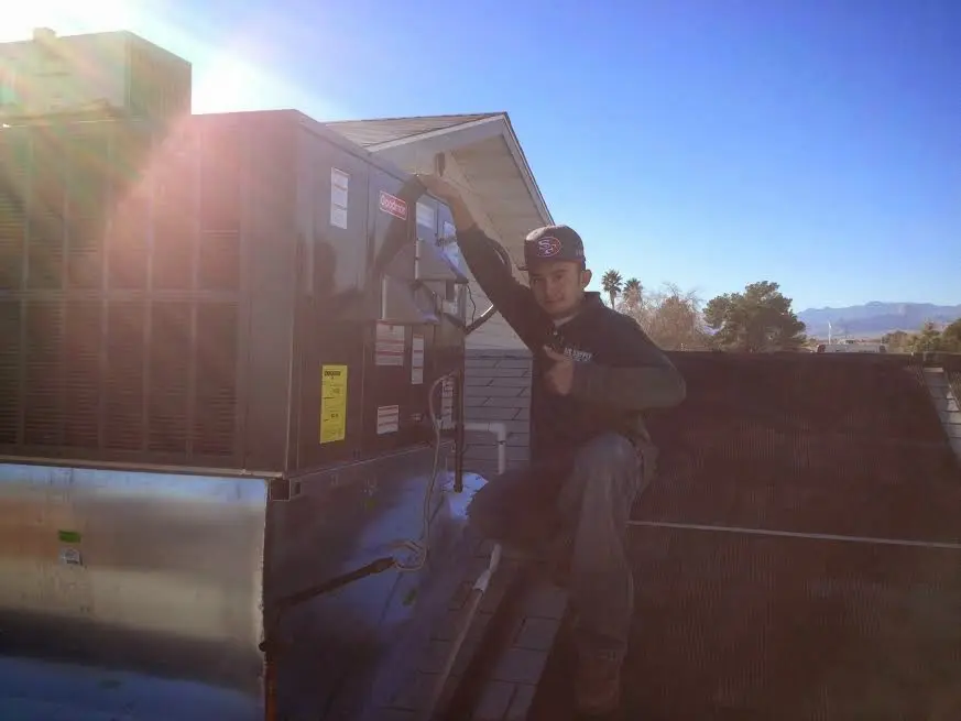 HVAC technician performing Boiler Repair on a rooftop unit in Kearney